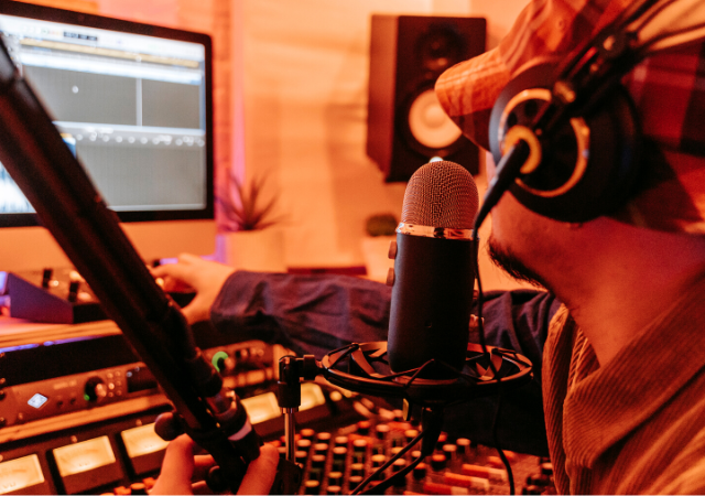 Un hombre en un estudio de música con un micrófono.