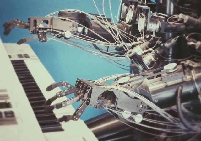 Manos robóticas tocando un teclado contra un fondo azul