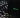Un portátil con el logo de Spotify en la pantalla se encuentra sobre una superficie oscura, rodeado de patrones de luz moteada que le dan un toque atmosférico.