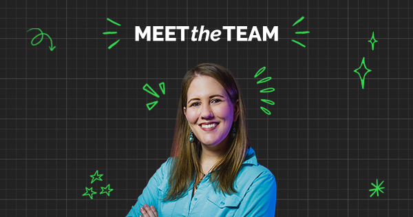 Una mujer sonriendo con una camisa azul posa con los brazos cruzados bajo el texto “Meet the Team”, sobre un fondo negro con cuadrícula y doodles verdes, destacando el espíritu de trabajo en equipo.