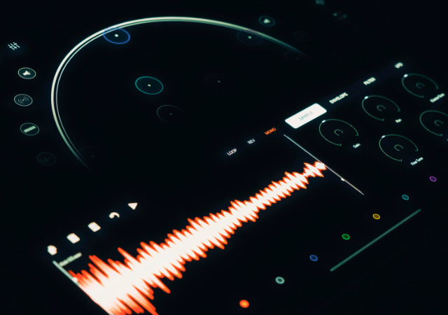 Una interfaz digital de audio muestra una onda sonora roja, controles circulares y varias perillas de ajuste de sonido impulsadas por IA en un entorno con poca luz.